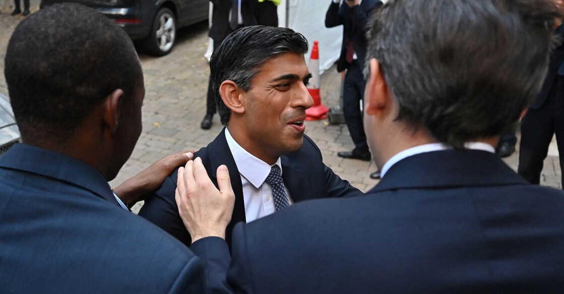 Rishi Sunak (centre) is greeted by colleagues as he arrives at Conservative Party Headquarters in central London, after having been announced as the winner of the Conservative Party leadership contest on Monday. Photo: AFP/ Justin Tallis 
