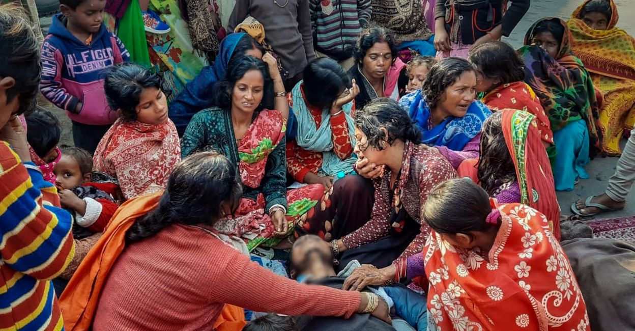 Family members and relatives of people, who died after consuming allegedly spurious liquor mourn near their mortal remains, at Ishuapur police station area in Bihar's Saran district, Wednesday, December 14, 2022. Photo: PTI