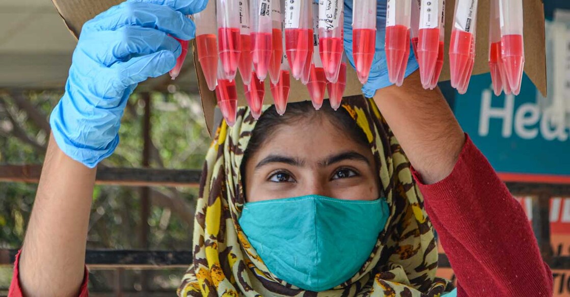 A health worker with swab samples of people collected for Covid-19 test, in Gurugram, Friday, February 18, 2022. Photo: PTI