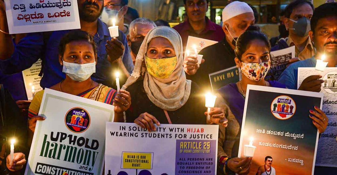 Citizens hold placards and candles in support of the hijab wearing students, in Bengaluru on February 19, 2022. Photo: PTI
