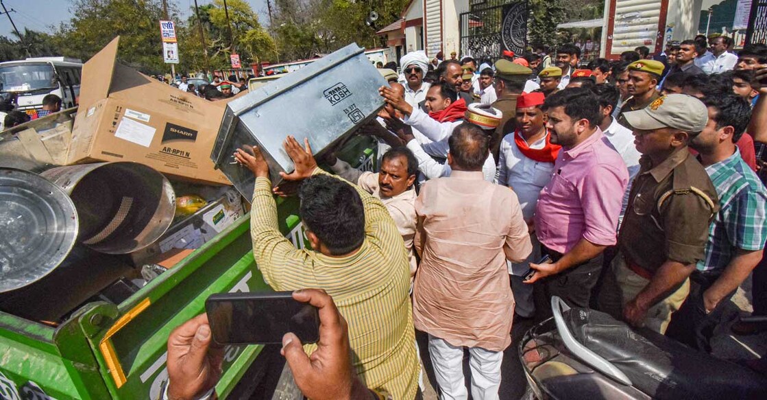 PTI03_09_2022_000108B Samajwadi Party workers check a loaded truck for possible EVMs outside the Gorakhpur University counting centre, a day before counting of votes for Assembly polls, in Gorakhpur, Wednesday, March 9, 2022. Photo: PTI
