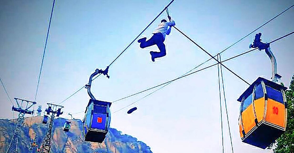 A tourist hangs on to a cable at Trikut Hill after a collision of cable cars, in Deogarh district in Jharkhand. PHOTO: PTI