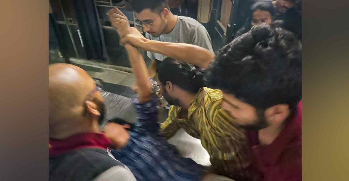Students make an injured collegemate lie down after a clash between students unions over serving of non-veg food during Navratri, at Jawaharlal Nehru University, in New Delhi on Sunday. Photo: PTI