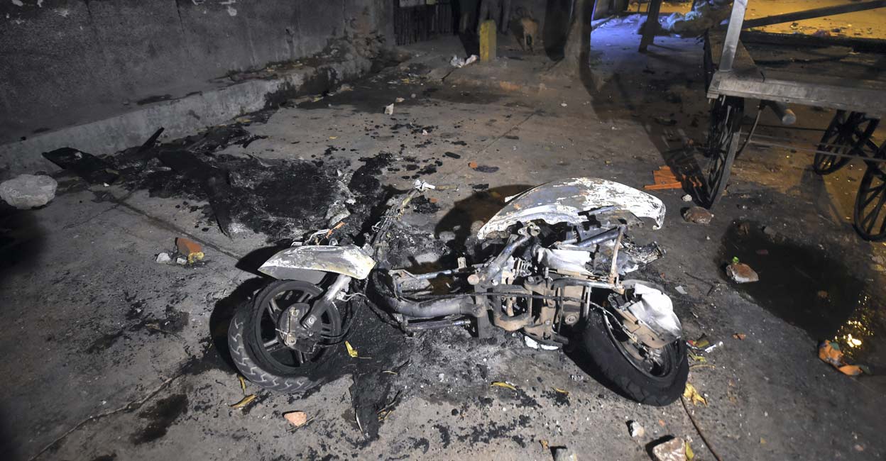 PTI04_16_2022_000301B Charred remains of a scooter after violent clashes broke out during a Hanuman Jayanti procession at Jahangirpuri, in New Delhi, Saturday, April 16, 2022. Photo: PTI/Shahbaz Khan