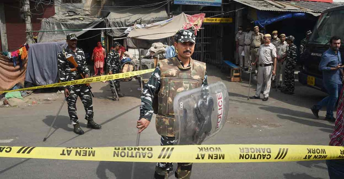 PTI04_18_2022_000054A Security personnel keep vigil after clashes broke out between two communities during a Hanuman Jayanti procession on Saturday, at Jahangirpuri in New Delhi, Monday, April 18, 2022. (PTI Photo/Shahbaz Khan)