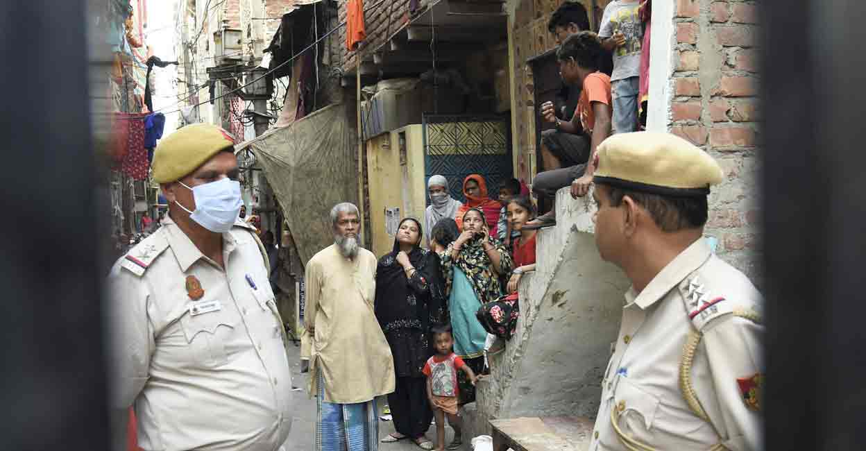 PTI04_18_2022_000064A Police personnel with residents outside their house after clashes broke out between two communities during a Hanuman Jayanti procession on Saturday, at Jahangirpuri in New Delhi, Monday, April 18, 2022. (PTI Photo/Shahbaz Khan)