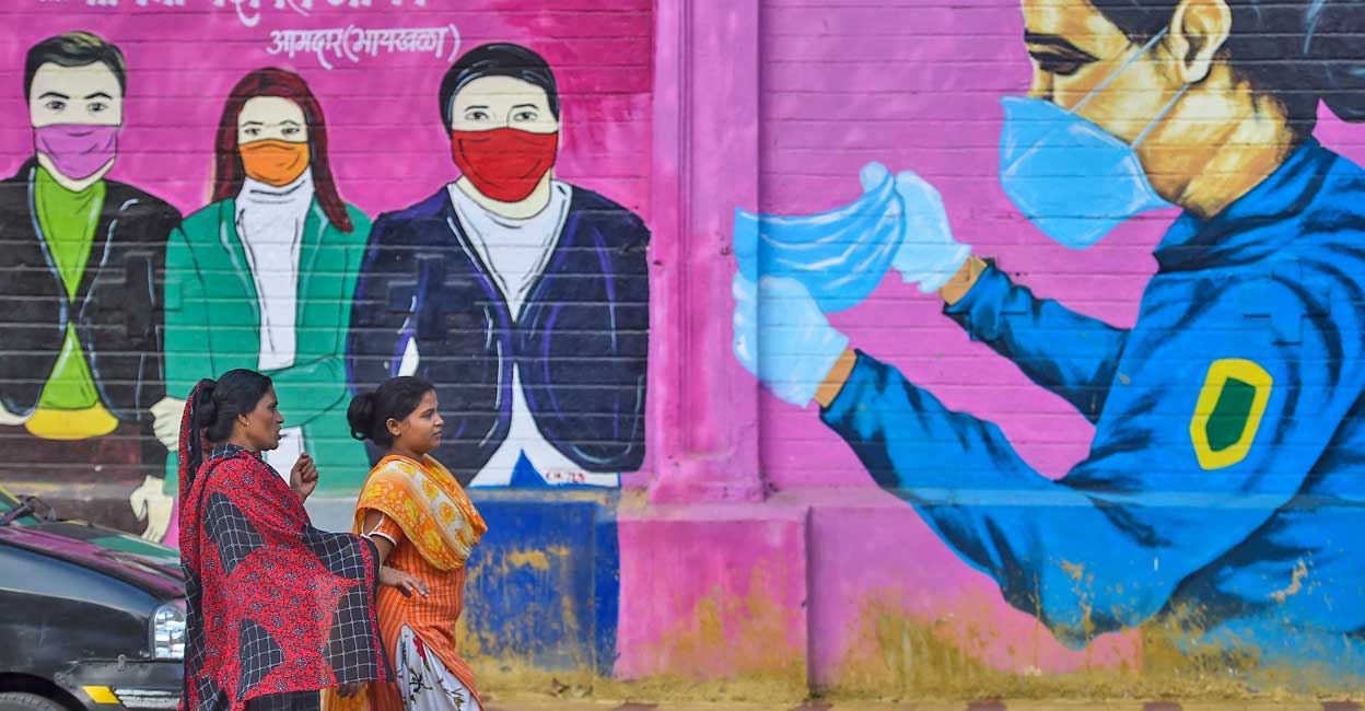 India reports 8,822 fresh COVID-19 cases, 15 deaths Women walk past a graffiti on a wall urging people to wear face masks in Mumbai, Monday, June 13, 2022. Photo: Kunal Patil/PTI
