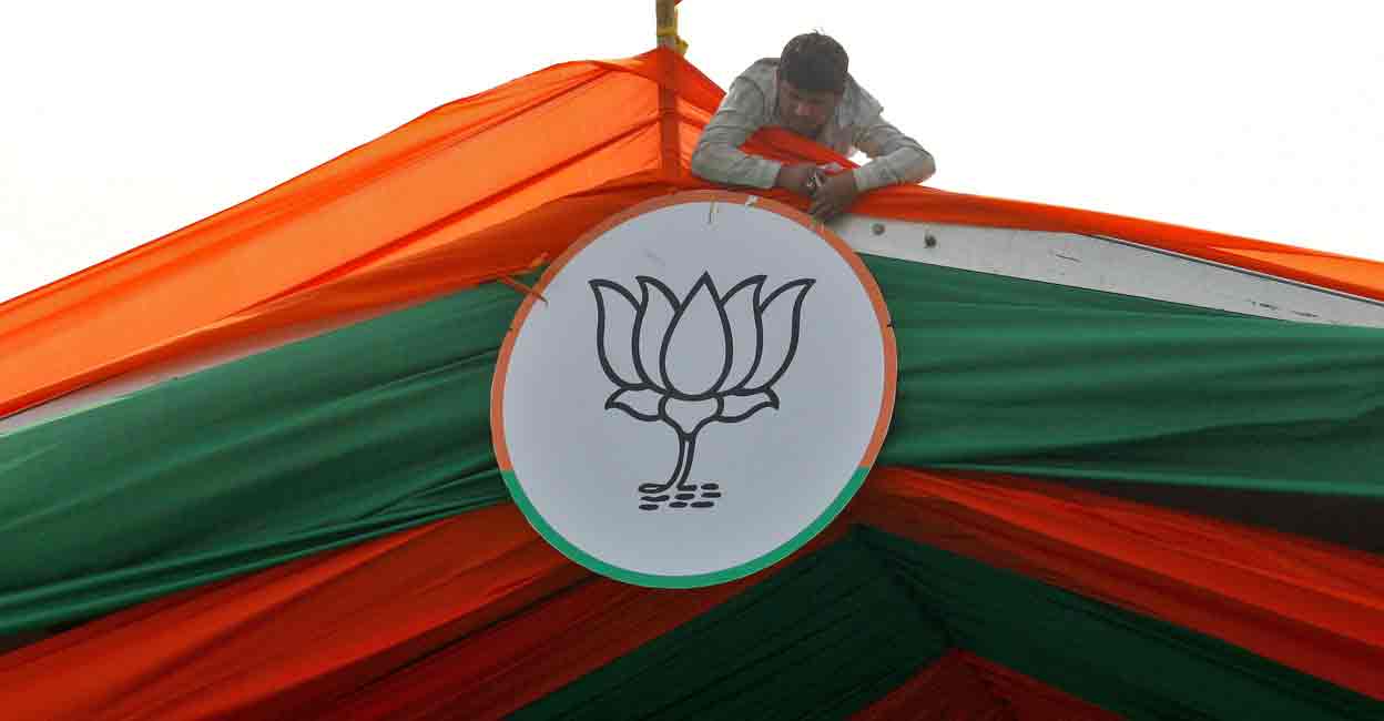 A man installs the symbol of India's ruling Bharatiya Janata Party (BJP) on a tent during an election campaign rally by the party in Prayagraj, India, February 24, 2022. Fille photo: REUTERS/Ritesh Shukla