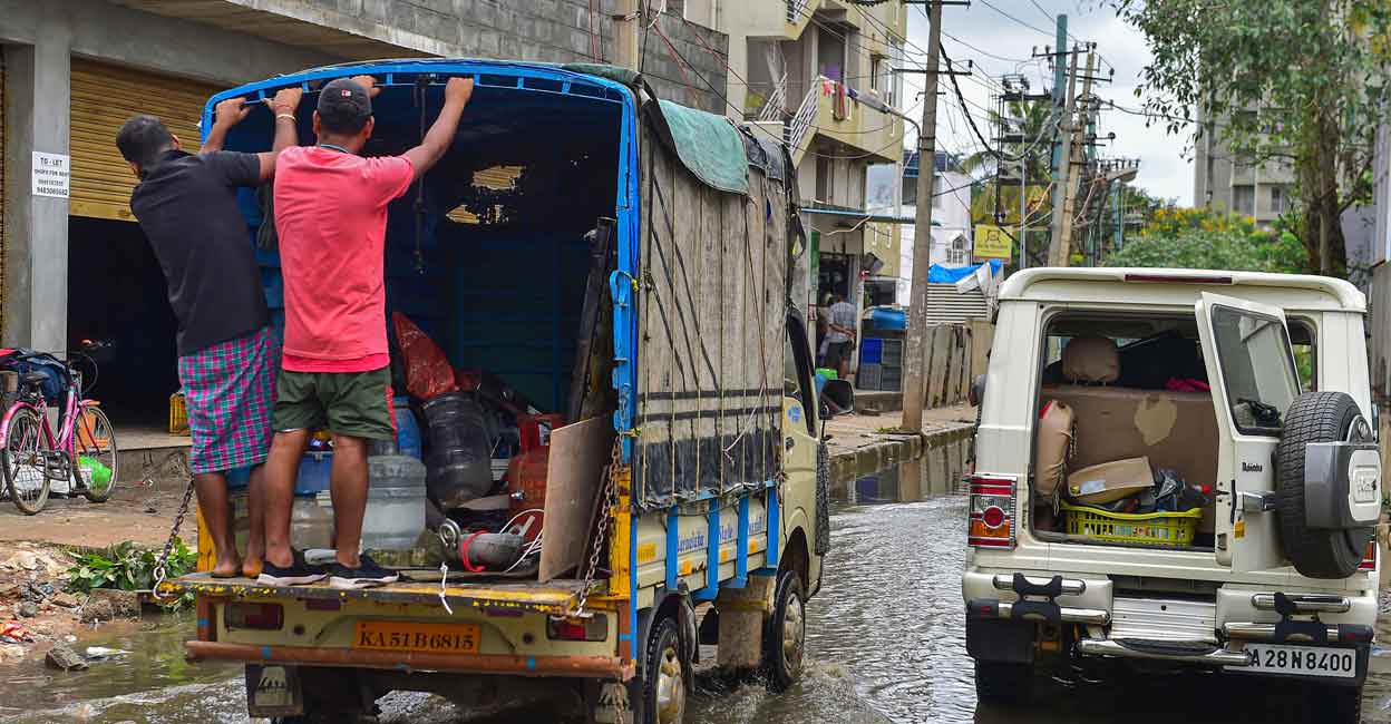 Bengaluru: Migrants carrying their belongings shift from a flooded locality of Bellandur after heavy monsoon rains, in Bengaluru, Wednesday, Sep. 7, 2022. (PTI Photo/Shailendra Bhojak) 