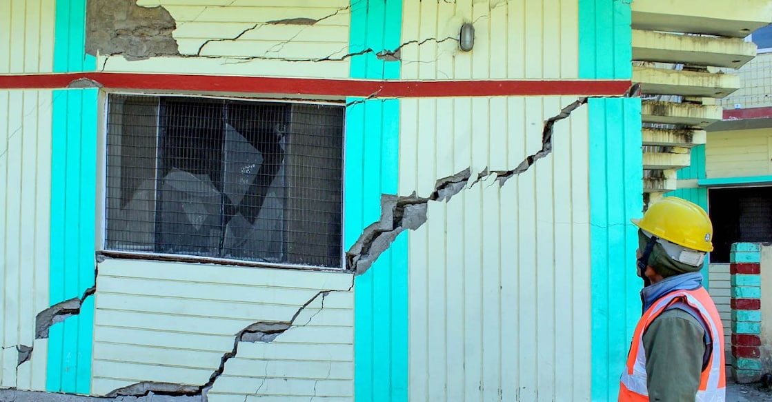 PTI01_16_2023_000150A A worker looks at cracks that appeared in a PWD Guest House, in land subsidence affected area in Joshimath: PTI