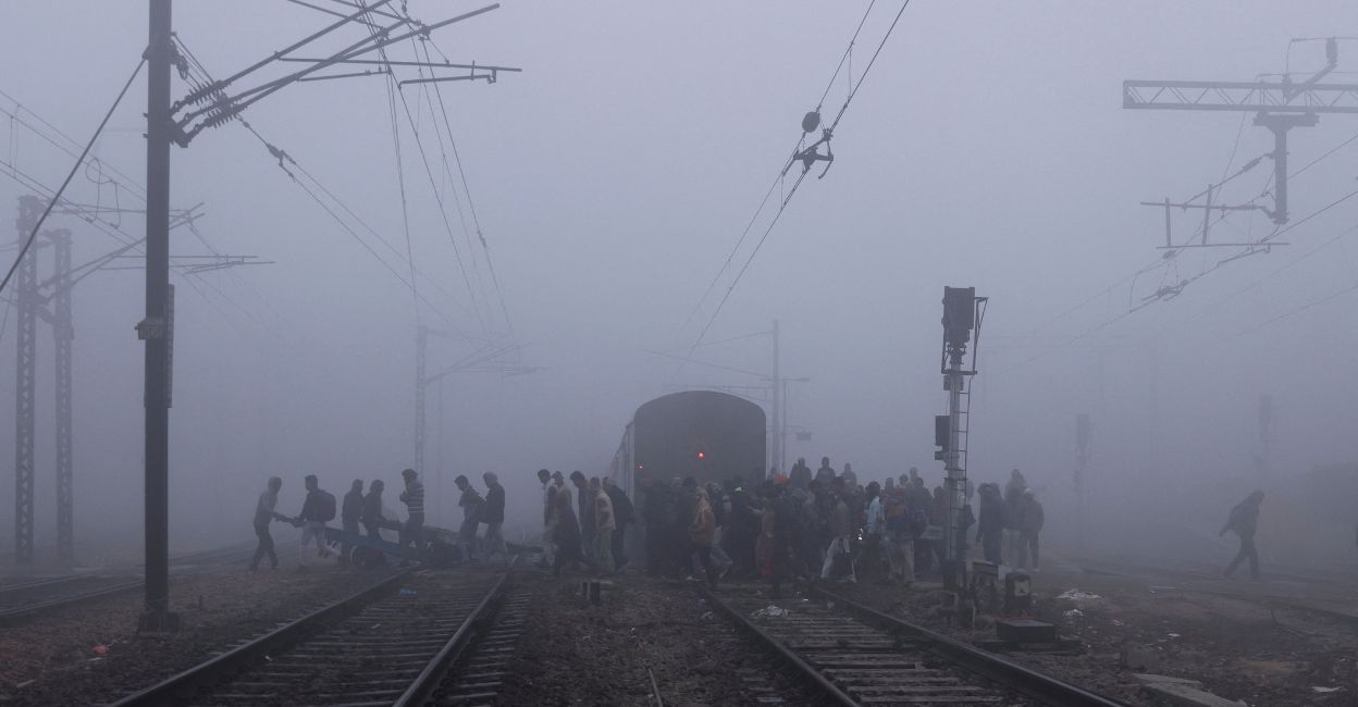 

People cross railway tracks amidst heavy fog on a cold winter morning in New Delhi, India, January 9, 2023. Photo: Reuters/Anushree Fadnavis.