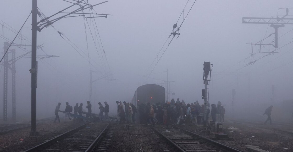

People cross railway tracks amidst heavy fog on a cold winter morning in New Delhi, India, January 9, 2023. Photo: Reuters/Anushree Fadnavis.