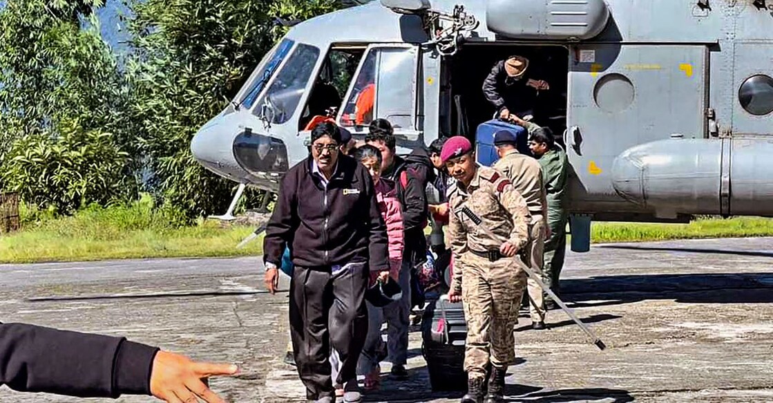Tourists evacuated from flood-affected Lachen by helicopter arrive at Ringhim Helipad, Mangan in North Sikkim. Photo: PTI