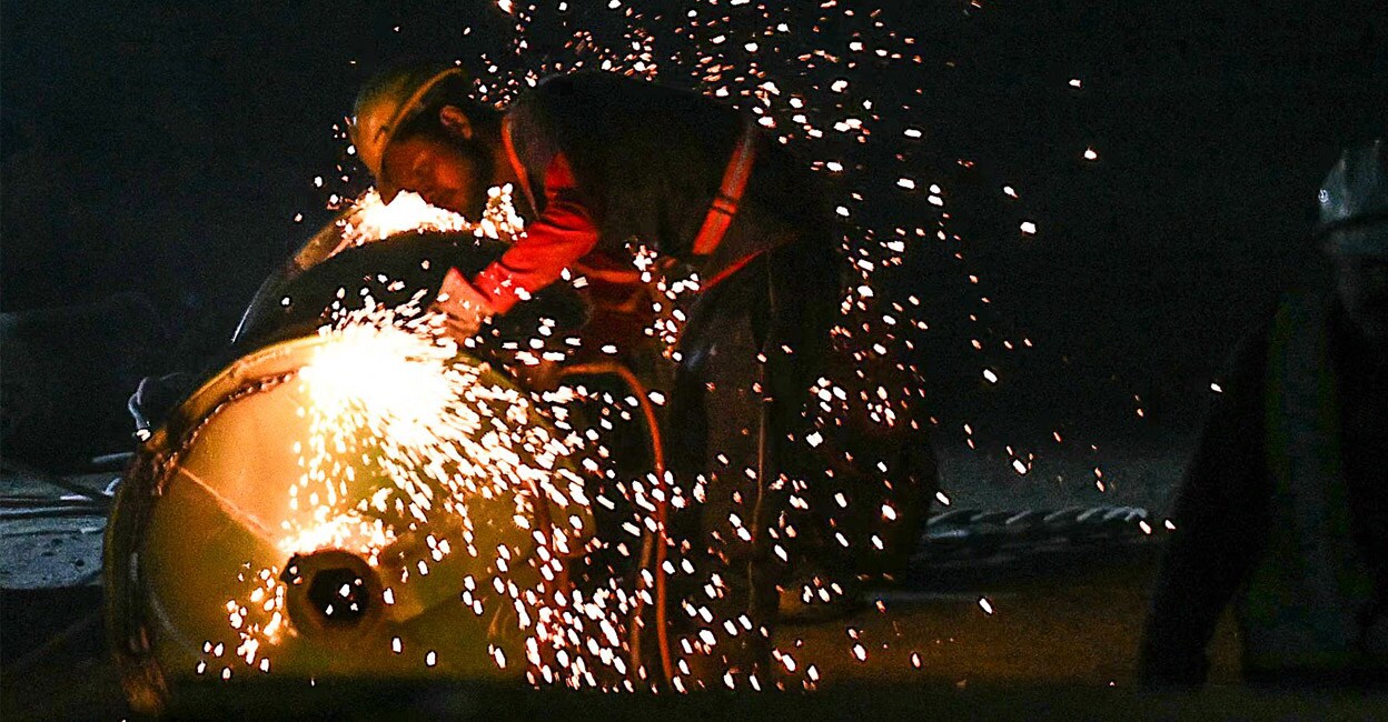 A rescue personnel welds a driller head during rescue operations for trapped constructions workers. Photo: Arun SANKAR/ AFP