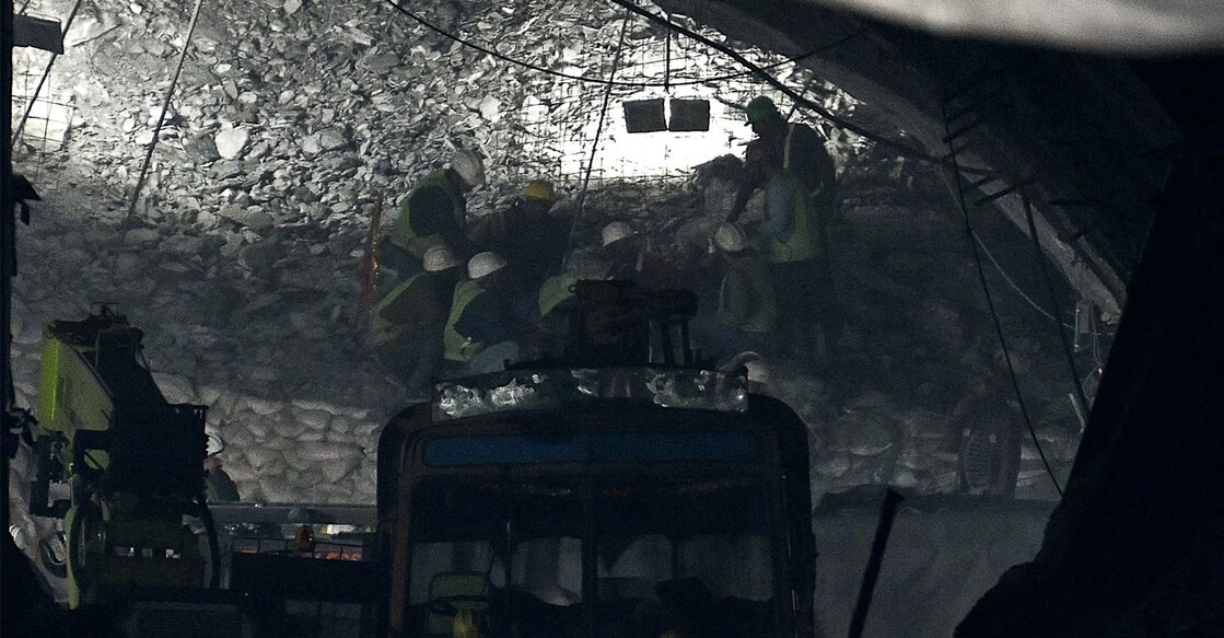 Rescue workers send food through a pipe during rescue operations for trapped constructions workers days. Photo: Arun SANKAR/ AFP