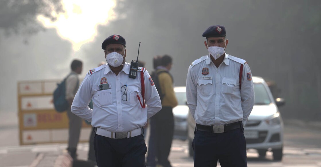 Traffic policemen wearing an anti-pollution mask regulate vehicular movement, in New Delhi on Tuesday. Photo: PTI Photo/ Kamal Kishore