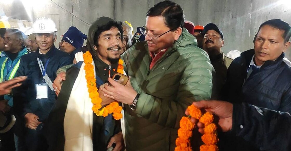 Contruction worker released from the tunnel interact with Chief minister of Uttarakhand Pushkar Singh Dhami (R). Photo: PTI