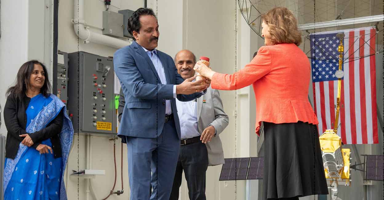 ISRO Chairman S Somanath receives the 'lucky peanuts' from JPL Director Laurie Leshin in the presence of Indian Ambassador and Deputy Chief of Mission Sripriya Ranganathan (left). Photo: NASA
