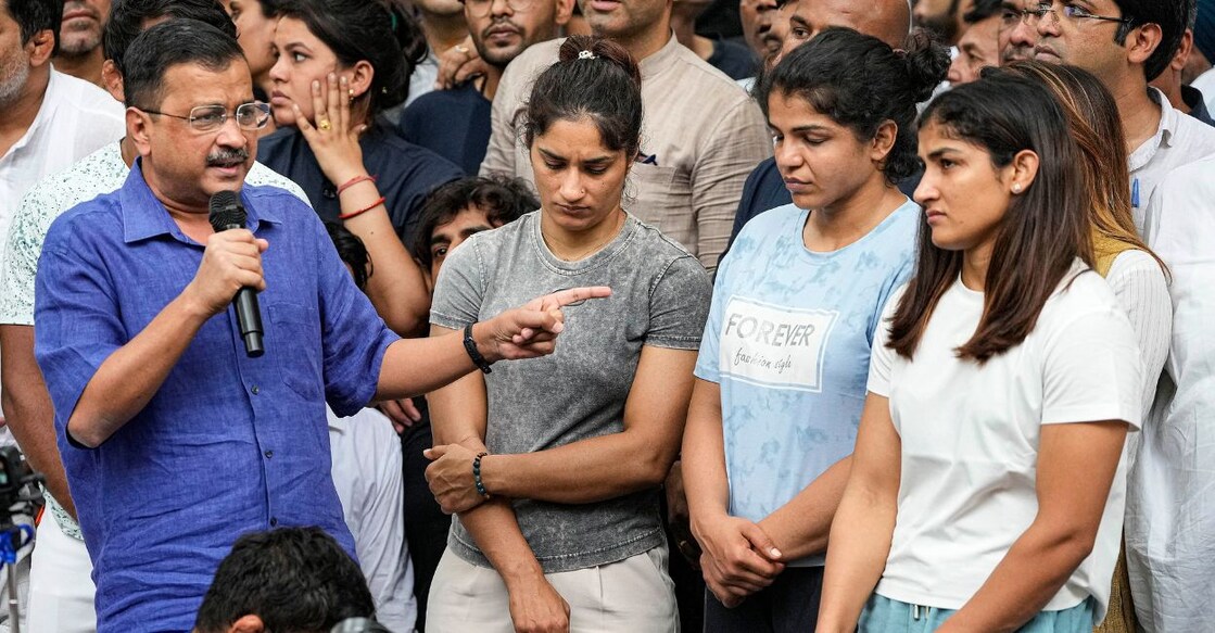 Delhi Chief Minister Arvind Kejriwal with wrestlers Vinesh Phogat, Sakshi Malik and Sangita Phogat during their protest at Jantar Mantar, in New Delhi, Saturday, April 29, 2023. Photo: PTI