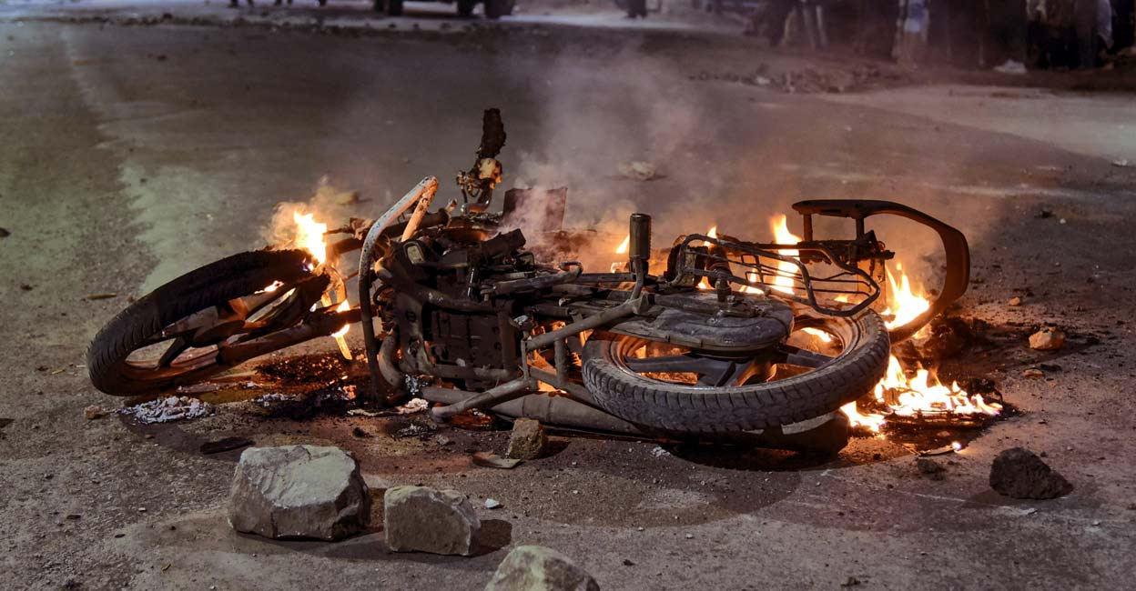 A vehicle set on fire during clashes between members of two communities over a social media post, in Akola, Maharashtra. Photo: PTI