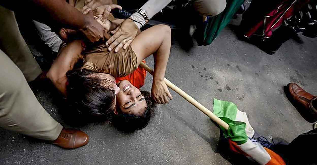 Security personnel detain wrestlers Vinesh Phogat and Sangeeta Phogat during wrestlers' protest march towards new Parliament building, in New Delhi, Sunday, May 28, 2023. Photo: PTI