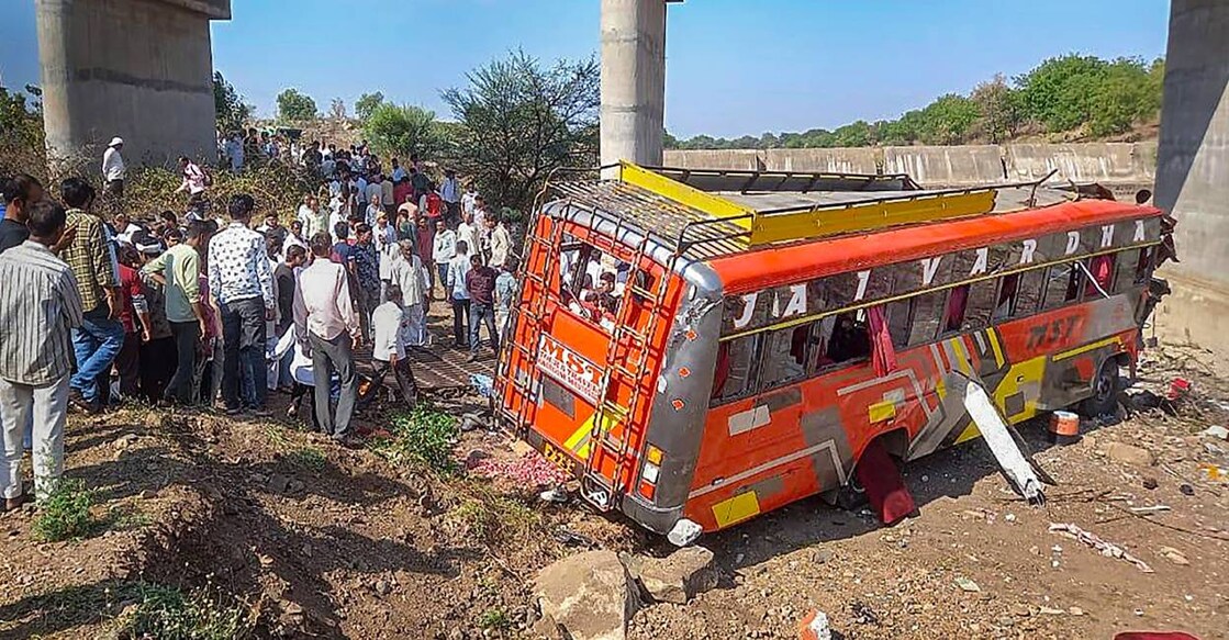  Locals gather at the site after a bus fell from a bridge in Madhya Pradesh's Khargone district. Photo: PTI