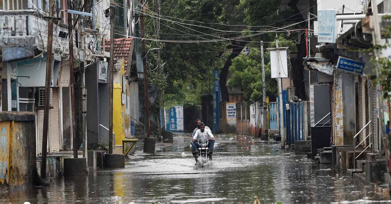 ASIA-WEATHER-INDIA-PAKISTAN A man rides a motorcycle through a waterlogged street in Mandvi before the arrival of cyclone Biparjoy in the western state of Gujarat, India, June 15, 2023. Photo: REUTERS/Francis Mascarenhas