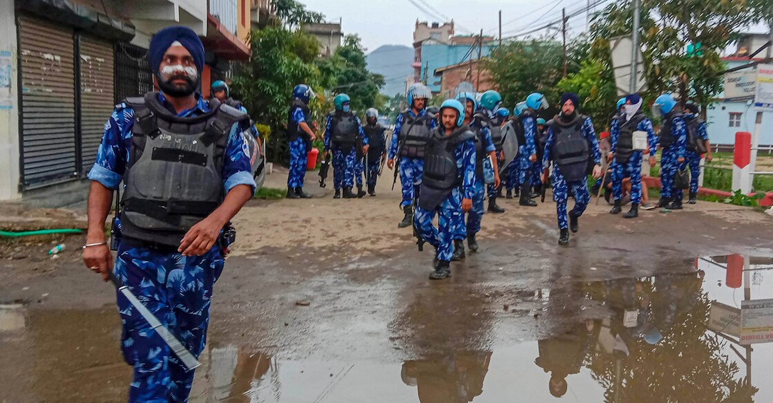 Security personnel stand guard at violence-hit Konung Mamang area during the ongoing ethnic clashes, in Imphal East district. File photo: PTI