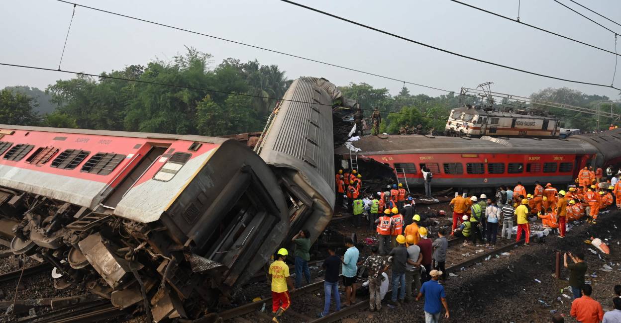 Rescue workers gather around damaged carriages during search for survivors at the accident site of a three-train collision near Balasore in Odisha. File Photo: AFP