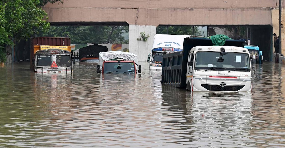 delhi yamuna Trucks are seen partially submerged in a flooded street after the Yamuna River overflowed due to monsoon rains. Photo: AFP