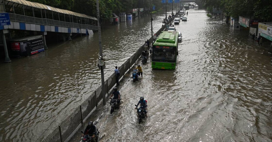 Vehicles ride through a flooded street after Yamuna river overflowed due to monsoon rains. Photo: AFP