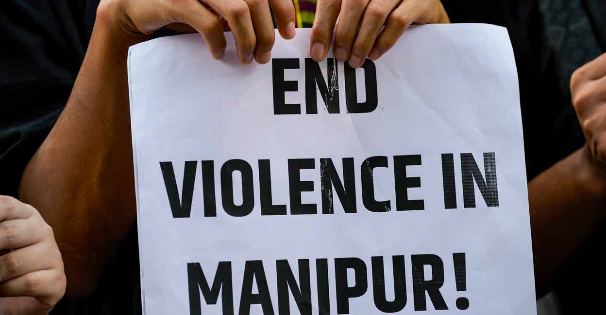 PTI07_21_2023_000311A A protester holds a placard during a protest against the ongoing ethnic violence in Manipur state, in New Delhi, Friday, July 21, 2023. Photo: PTI