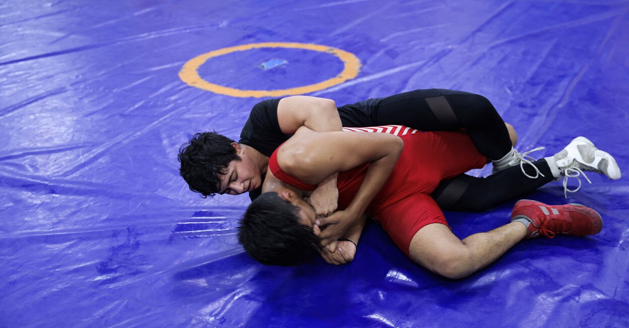 Simran Ahlawat, a wrestler, practices wrestling with another male wrestler at an akhara in New Delhi, India, June 19, 2023. REUTERS/Anushree Fadnavis