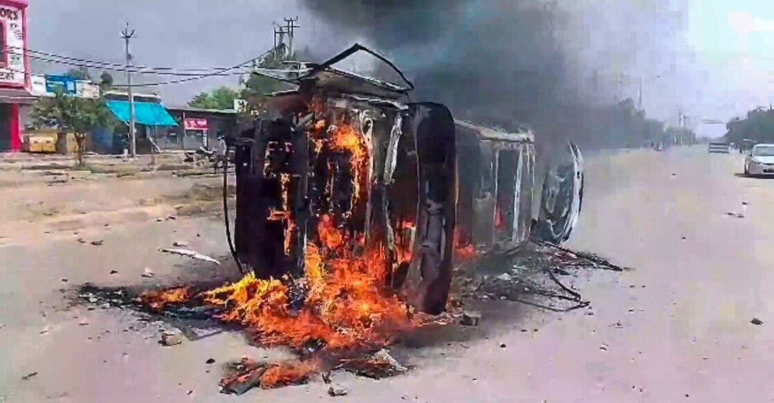 A vehicle set on fire during clashes that broke out during a religious procession in Nuh, Haryana on Monday. Photo: PTI