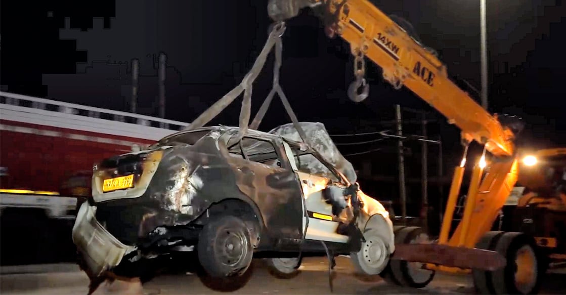 A crane removes the wreckage of a vehicle that was set on fire during clashes between two groups, at Sohna in Gurugram district, Tuesday, Aug 1, 2023. Photo: PTI