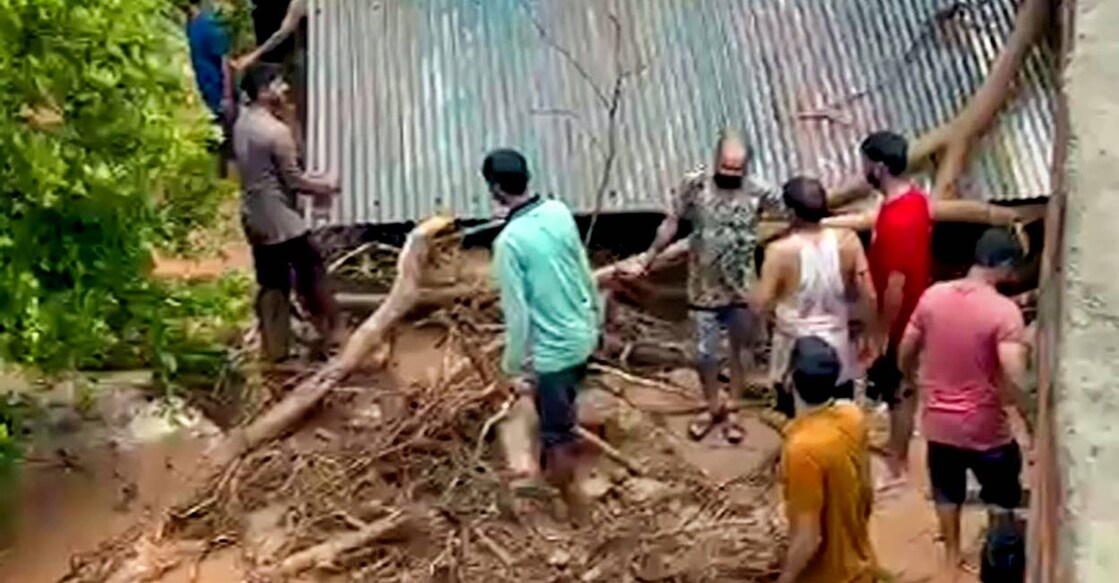 People remove fallen trees and muck that has damaged houses after heavy monsoon rains at Himachal Pradesh. Photo: PTI