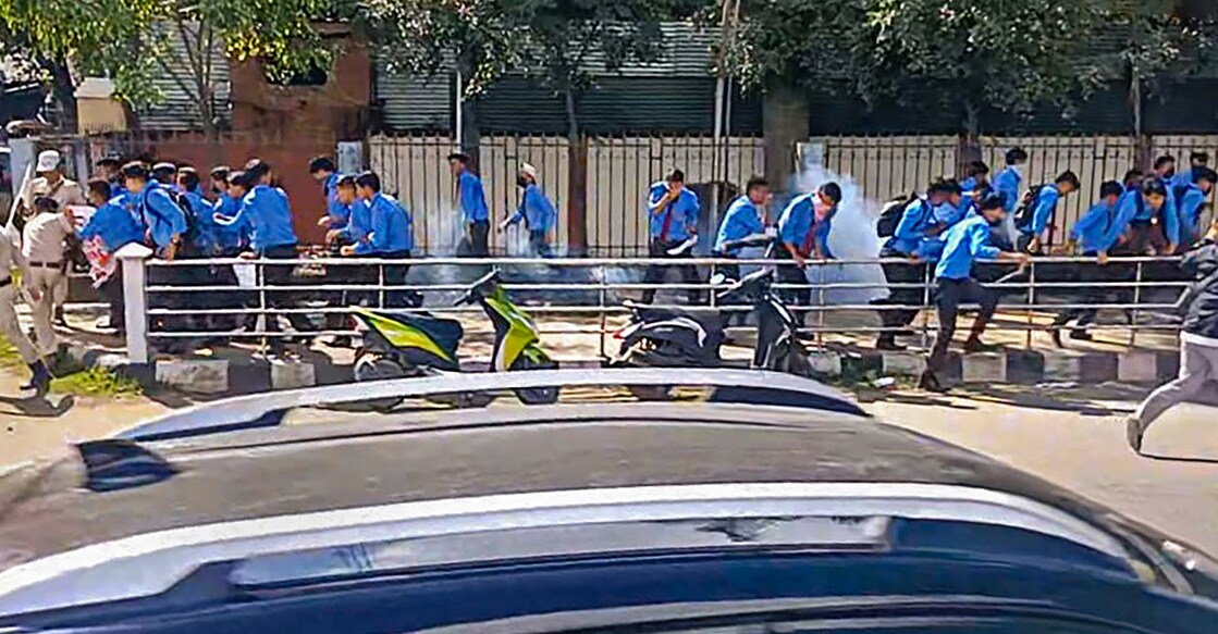 Students run away during a protest against the killing of two youths who were allegedly kidnapped in July, after the police fired tear gas shells and baton-charged the protestors, in Imphal, Tuesday, Sept. 26, 2023. More than 30 students, mostly girls, were injured. Photo: PTI