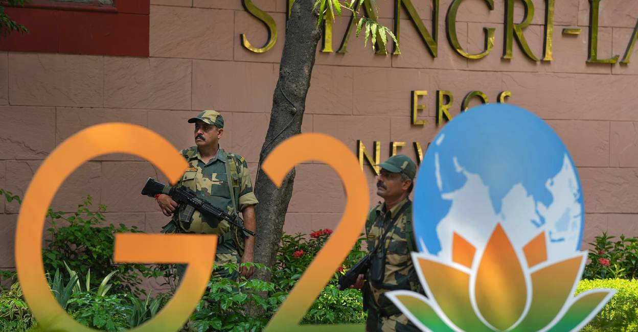  Security officials stand guard near a G20 Summit logo installed at Shangri-La Hotel as part of preparations for the upcoming summit, in New Delhi. Photo: PTI