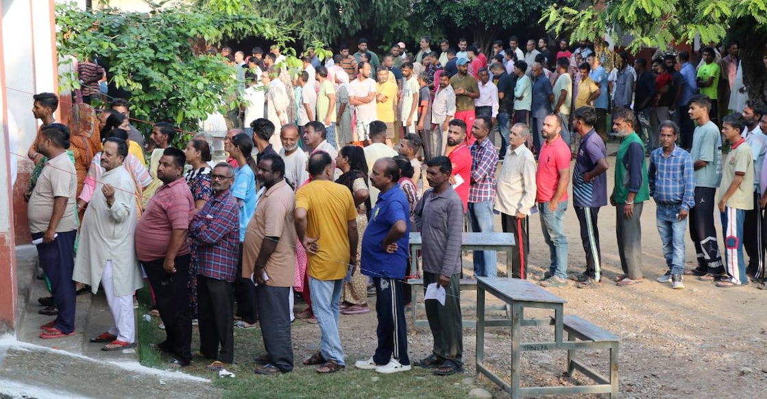 People wait in queues to cast their votes at a polling booth during the third and final phase of Jammu & Kashmir Assembly elections, in Jammu.  Photo: PTI