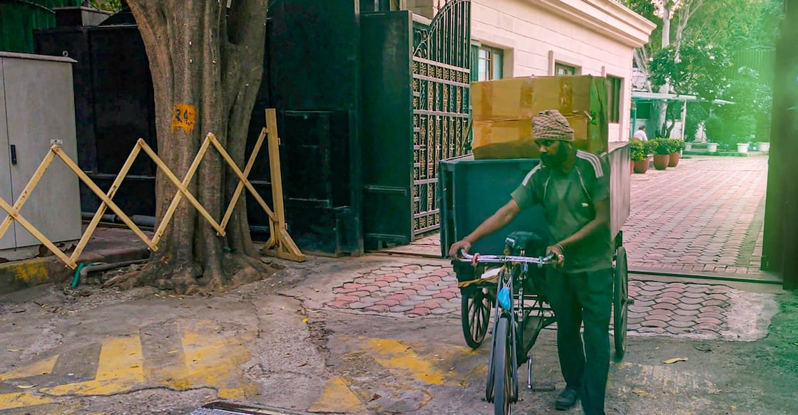 A worker carrying goods on a cart leaves from 6, Flagstaff Road in Civil Lines, the official residence of Chief Minister of Delhi in New Delhi on Wednesday. Photo: PTI