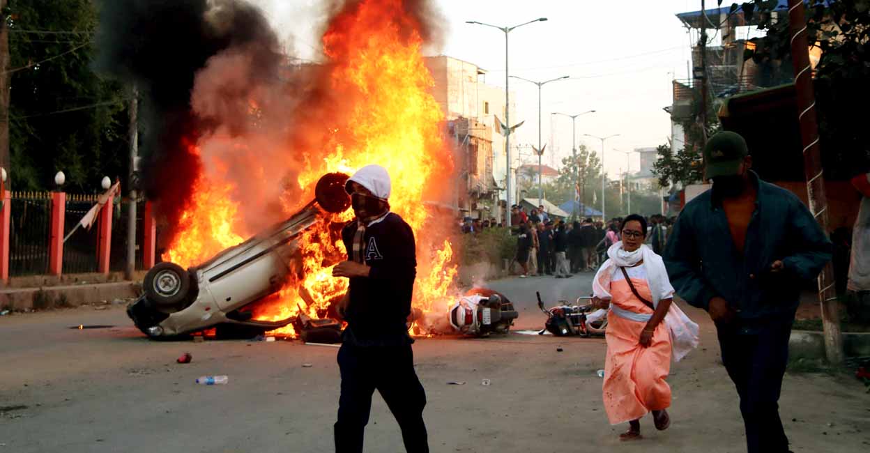 Imphal: People escape as smoke and flames billow out of vehicles which were set on fire set on fire during demonstrations after three bodies, suspected to be of six missing persons from Jiribam district, were found near the Manipur-Assam border on Friday night, in Imphal, Saturday, Nov. 16, 2024. (PTI Photo)(PTI11_16_2024_000374A)