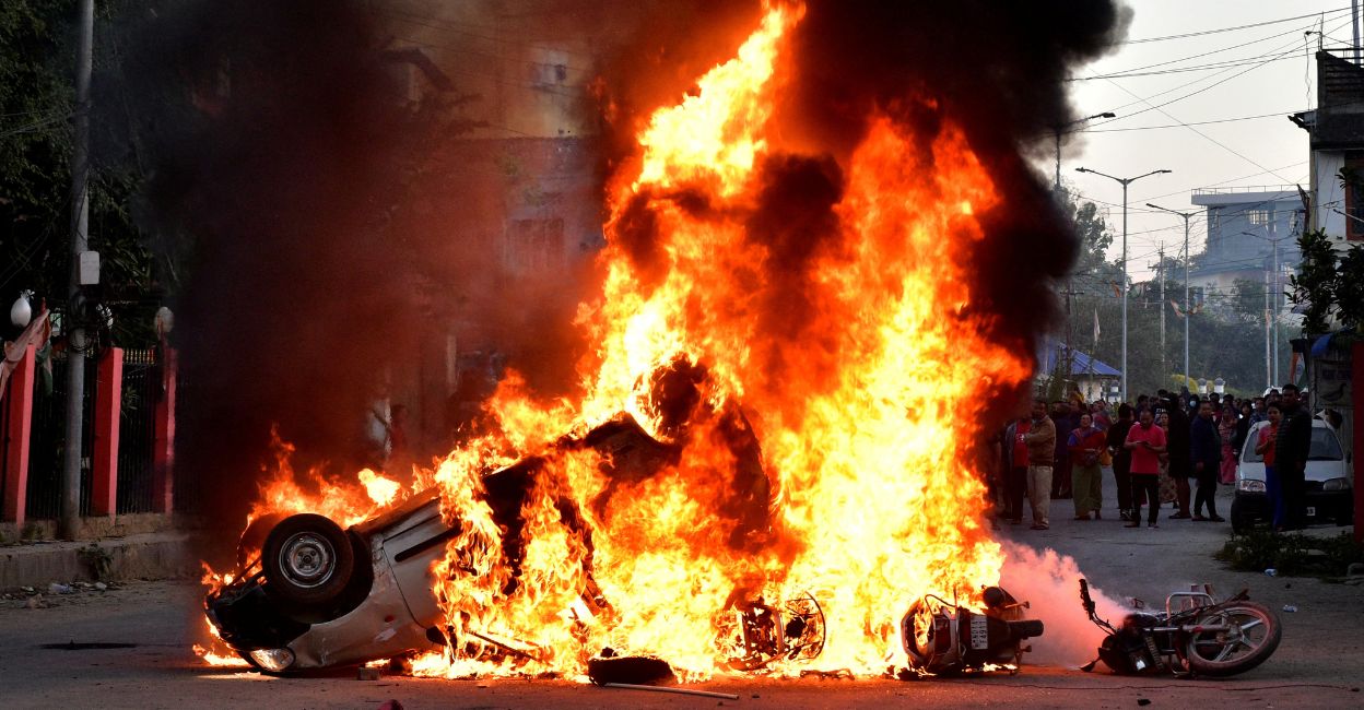 Vehicles burn as demonstrators stand during a protest against the recent killings, in Imphal West, in Manipur, on November 16, 2024. Photo: Reuters/Stringer