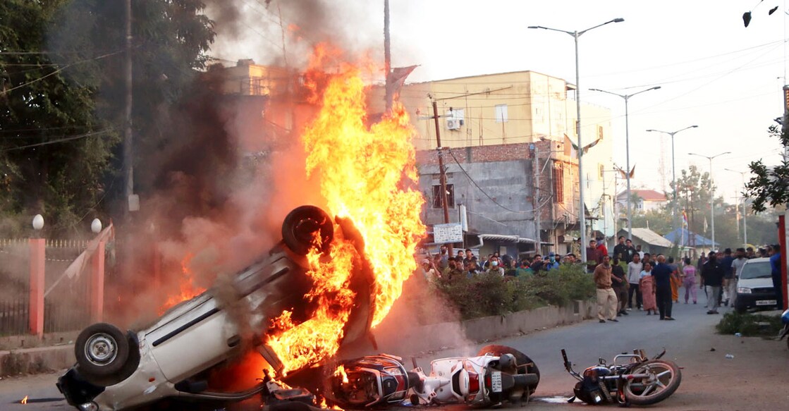 Smoke and flames billow out of vehicles which were set on fire during protests. Photo: PTI