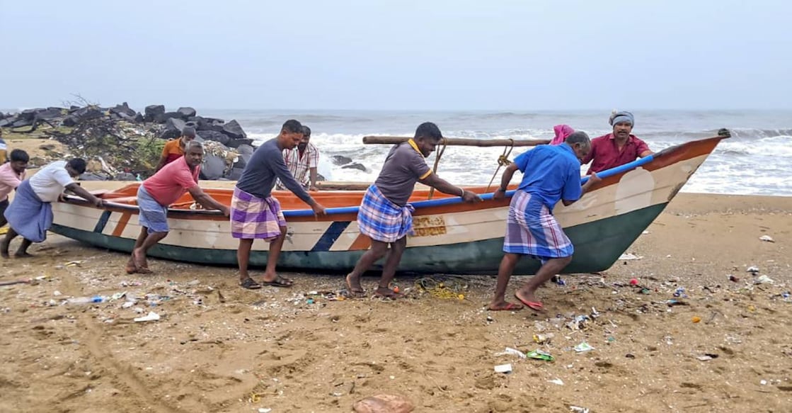 Fishermen move a boat to a harbour amidst a warning issued by the India Meteorological Department (IMD) that a deep depression over the southwest Bay of Bengal is likely to intensify into Cyclone 'Fengal'. Photo: PTI