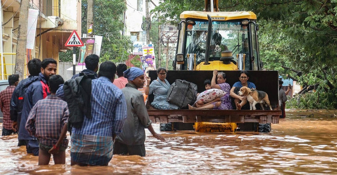 People move through a flooded street after heavy rainfall in Puducherry on December 1, 2024, following the landfall of cyclone Fengal in India's state of Tamil Nadu. Photo: PTI.