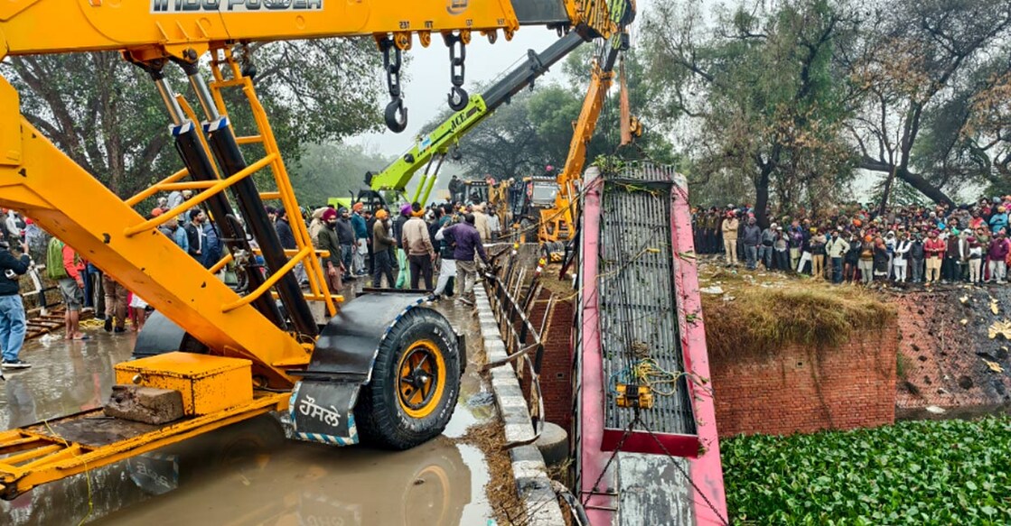 A crane pulls the wreckage of a bus that fell into a nullah after an accident in Bathinda. Photo: PTI.