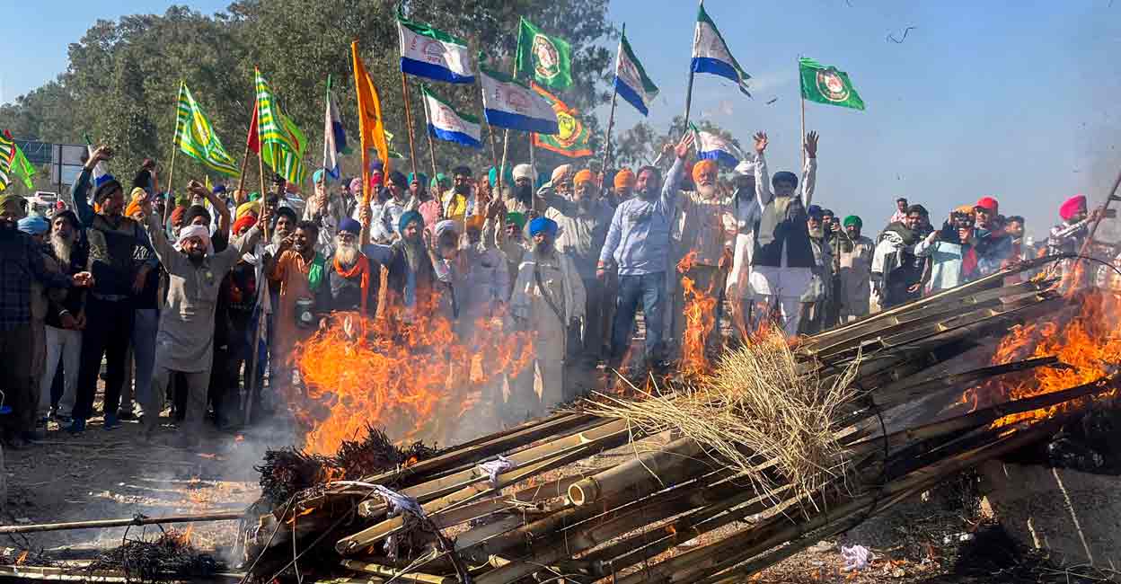 PTI02_26_2024_000250B Farmers holding flags shout slogans against corporate houses during a protest as part of their 'Delhi Chalo' march, near the Punjab-Haryana Shambhu border, in Patiala district, Monday, Feb. 26, 2024. Photo: PTI