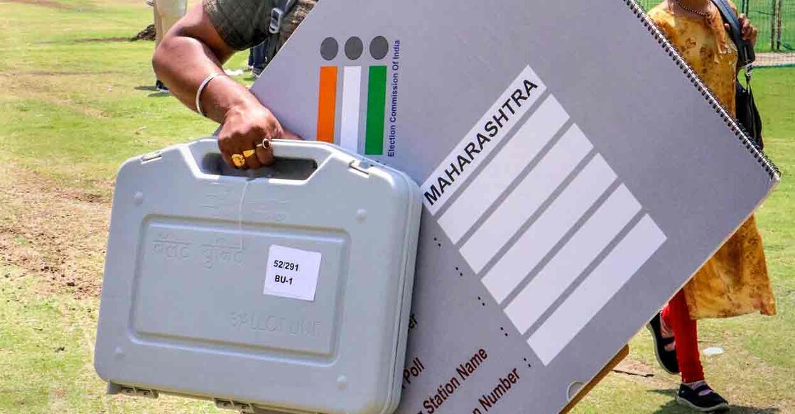 A polling official carries an Electronic Voting Machines (EVM) and other election material at a distribution centre on the eve of the first phase of Lok Sabha elections, in Nagpur, Thursday, April 18, 2024. Photo: PTI