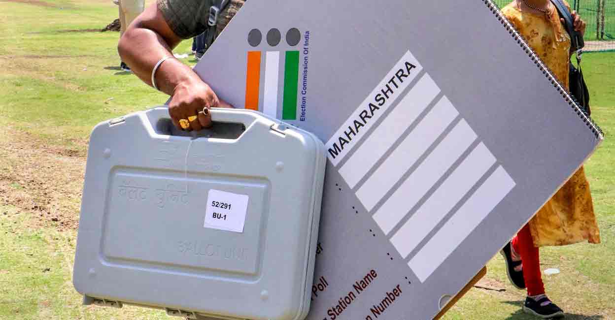 A polling official carries an Electronic Voting Machines (EVM) and other election material at a distribution centre on the eve of the first phase of Lok Sabha elections, in Nagpur, Thursday, April 18, 2024. Photo: PTI