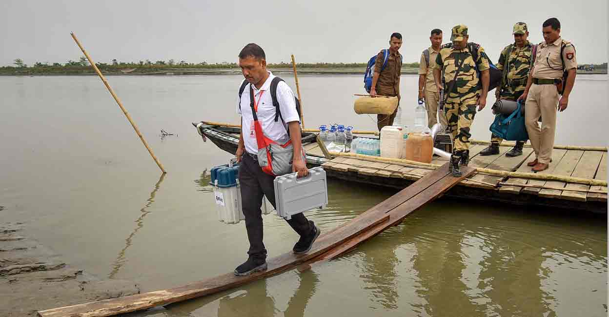 PTI04_18_2024_000136B Polling officials and security personnel with EVMs and other election materials disembark from a ferry on their way to a polling station ahead of the first phase of Lok Sabha elections, in Golaghat, Assam, Thursday, April 18, 2024. Photo: PTI